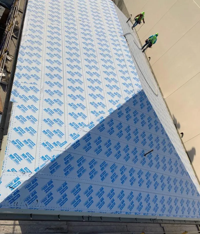 Professional roofers installing underlayment on a metal roof in Midway City